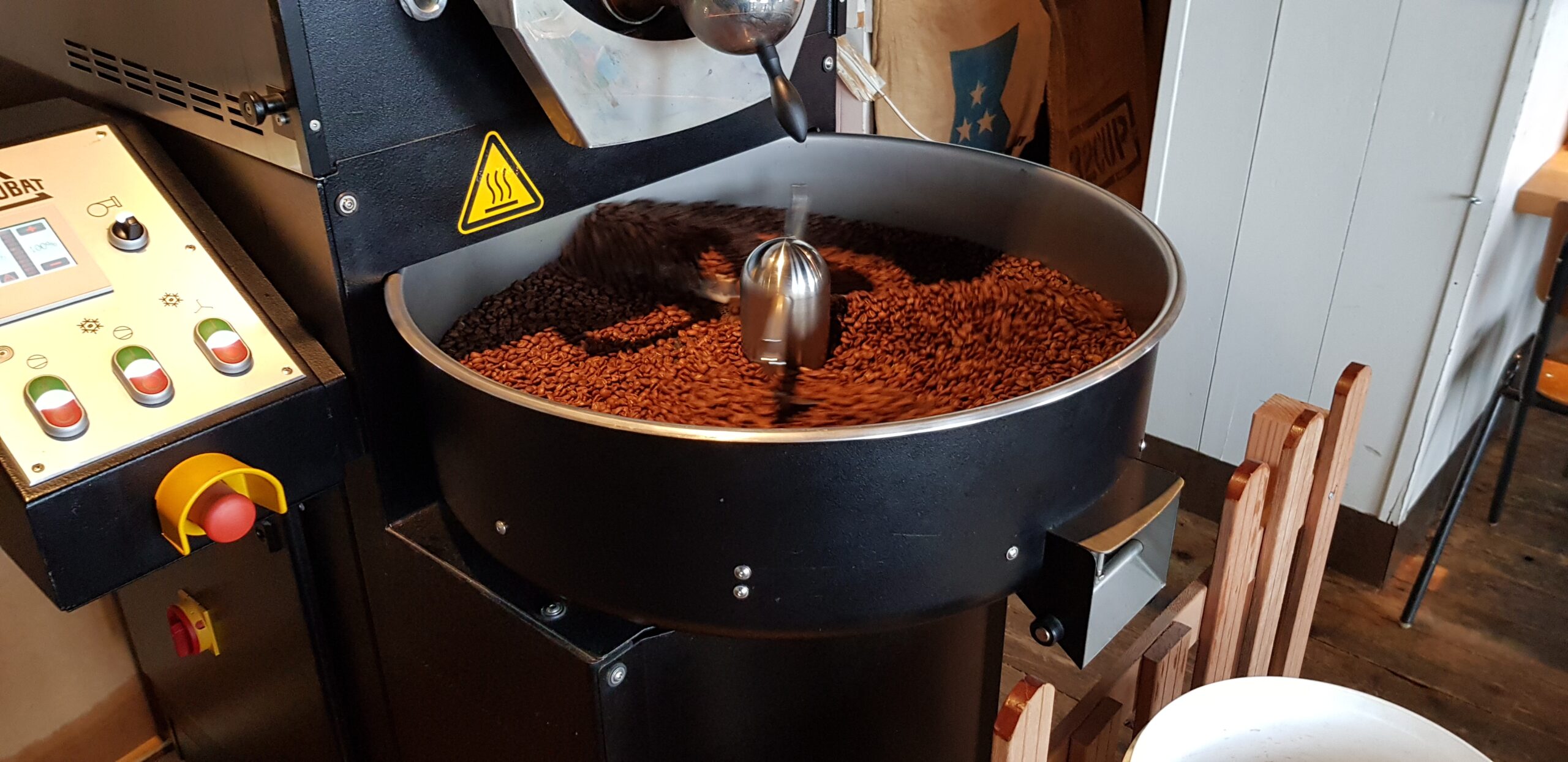 Vers gebrande koffiebonen in de trommel van de brander