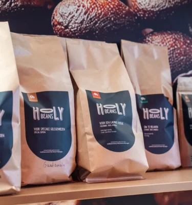 Het hele assortiment Holy Beans koffie in kilozakken en pouches op het schap