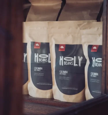 Drie zakken Holy Beans koffie in de houten kast van de winkel aan de Franseplaats