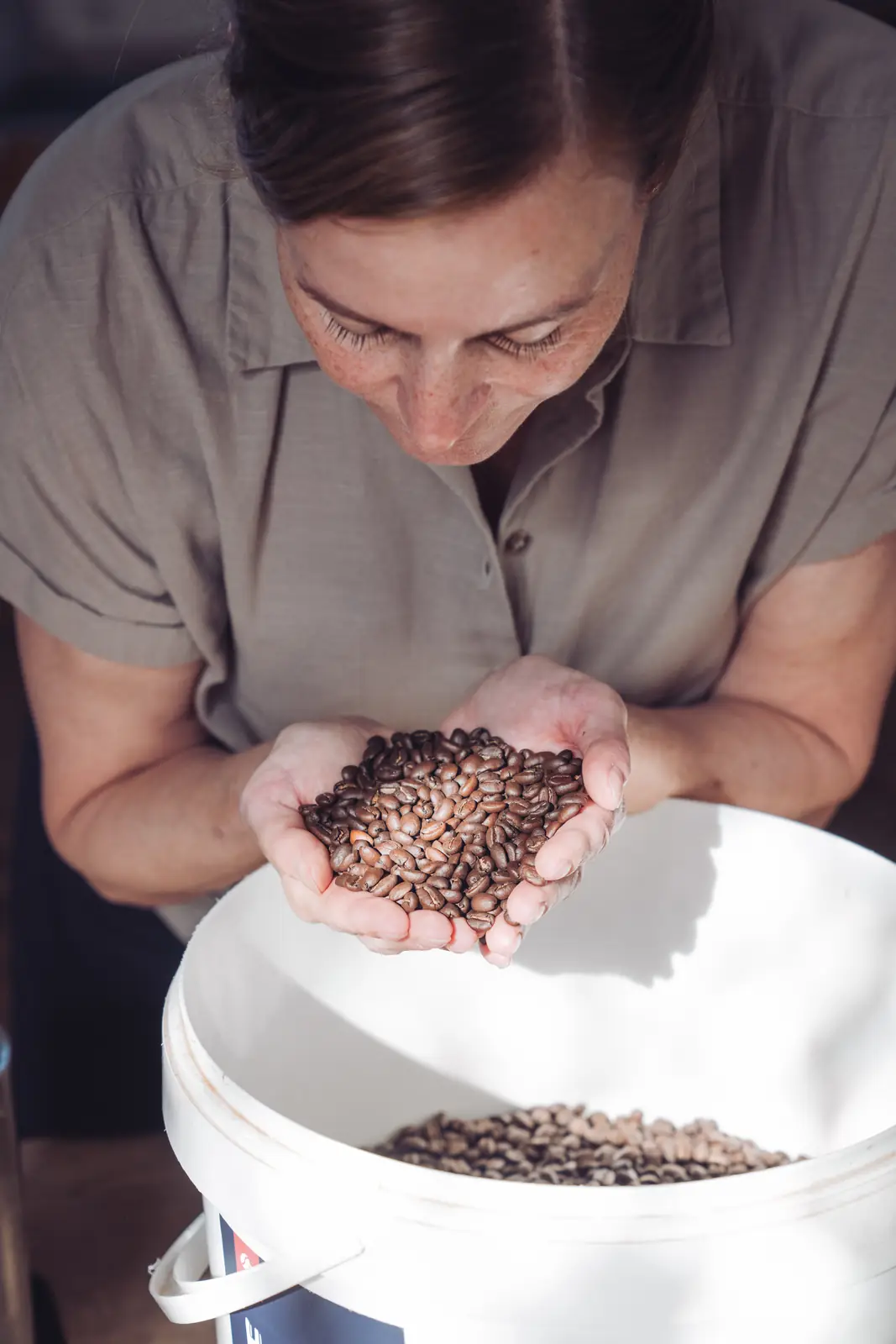 Ilfa de Roo ruikt aan een handvol versgebrande koffiebonen